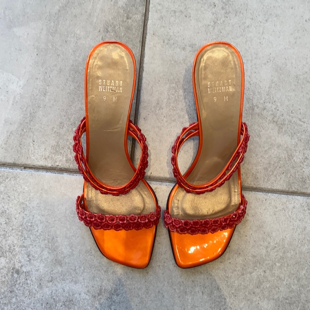 Stuart Weitzman orange kitten heels with flower and rhinestone detail.